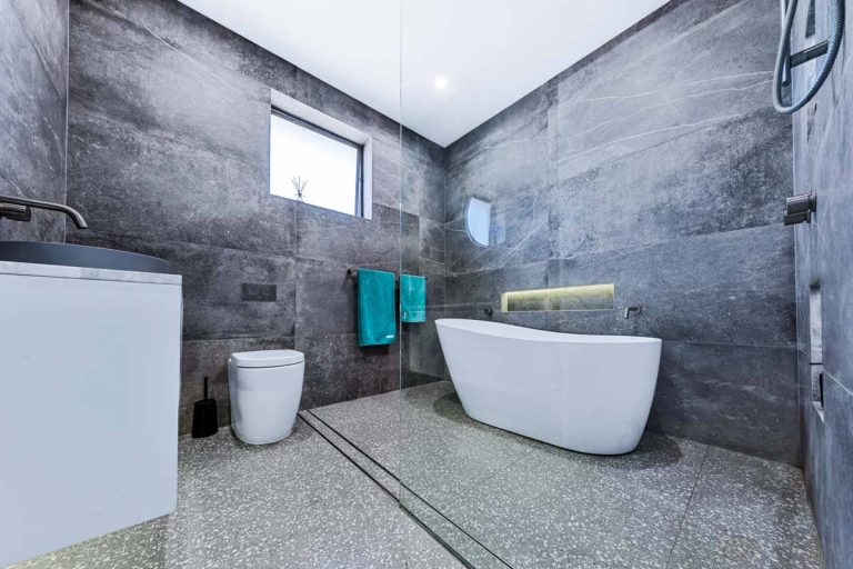 Passionbuilt-bathroom-renovation-Roselands-Sydney-with-open-shower-and-white-caroma-freestanding-bath